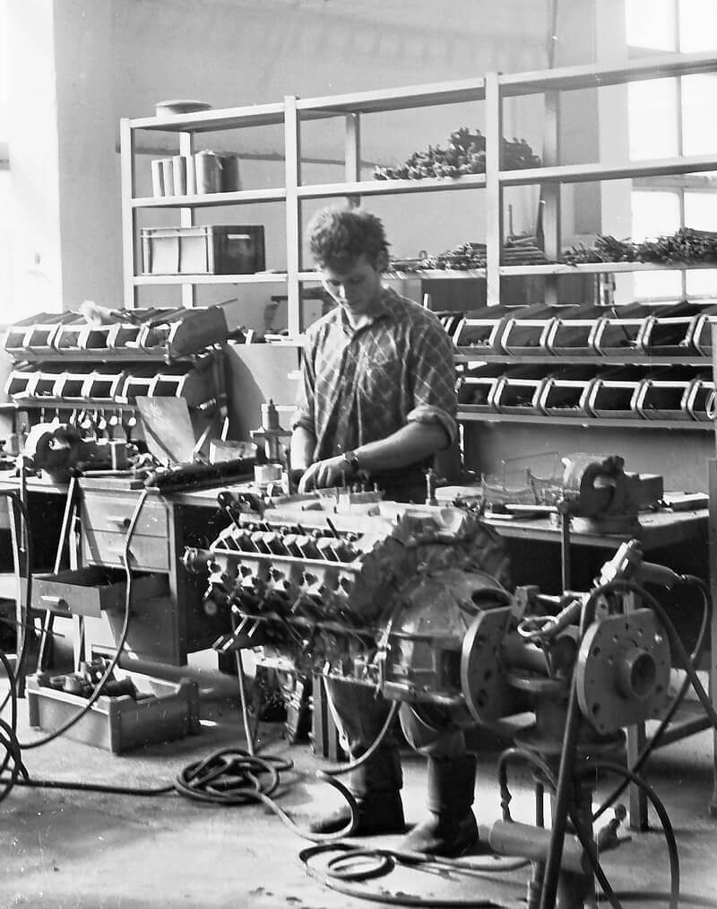 a historic picture of a man working on an engine in Kuusalu Factory